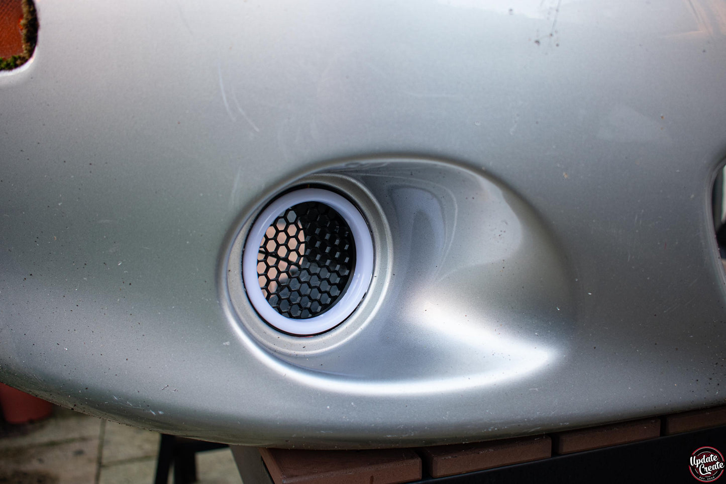 LED Halo light mounted to a custom 3D printed housing installed onto an OEM silver Mazda Mx5 NB bumper.